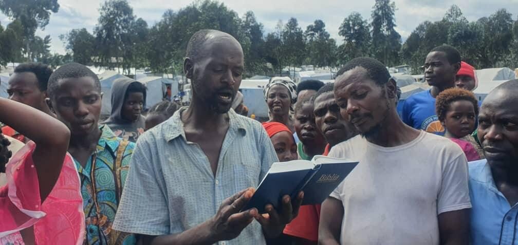 NCE outreach ministers serving a displaced family in a camp