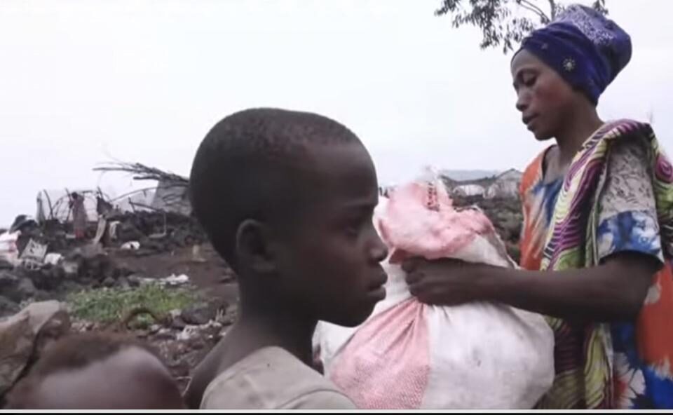 Young girl seated with a water container and supplies
